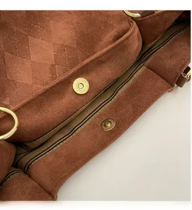 Close-up of vintage brown suede tote bag with quilted pattern and gold magnetic buckle