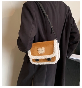 Détail du sac à bandoulière marron pelucheux avec écusson ours et bordure en fourrure