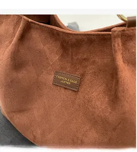 Macro detail of brown frosted tote bag showing quilted texture and fashion leather tag