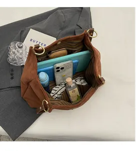 Spacious interior of brown suede tote bag showing tablet, phone and zipped pocket