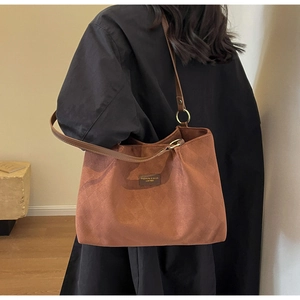 Close-up of vintage brown frosted leather tote bag with diamond quilted pattern and metal rings