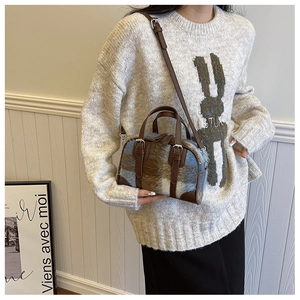Blue and brown plaid plush Boston bag with leather handles shown in a lifestyle setting