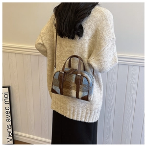 Detail of Boston bag with blue-brown plaid plush fabric and leather shoulder strap