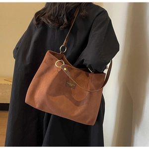 Detail of vintage brown suede tote bag with diamond lattice embossing and metal rings