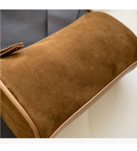 Detail shot of brown suede Boston bag showing soft texture and contrast edge stitching