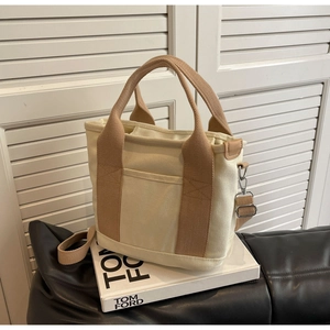 Detail of beige canvas tote bag showing high-density straps and metal swivel buckle
