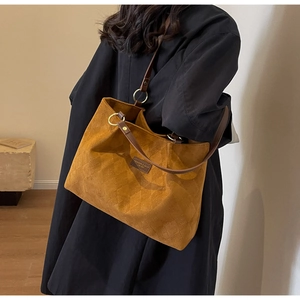 Detail of caramel frosted tote bag with quilted texture and gold hardware on shoulder