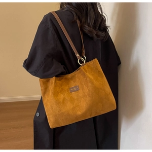 Detail of vintage matte brown tote bag showing quilted texture and metal strap rings