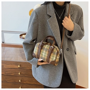 Detail view of plaid Boston bag in green and brown wool with premium leather trim