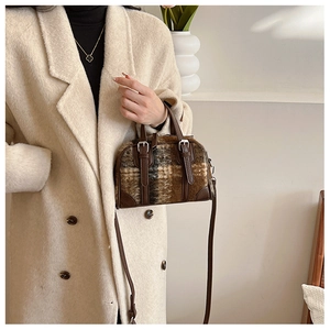Detail of checkered Boston bag in brown wool with leather trim and silver metal hardware