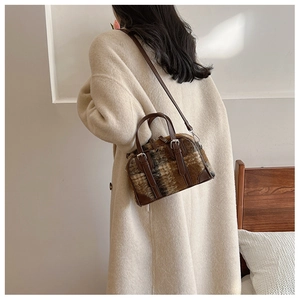 Brown plaid faux fur Boston bag shown worn crossbody in a warm interior setting
