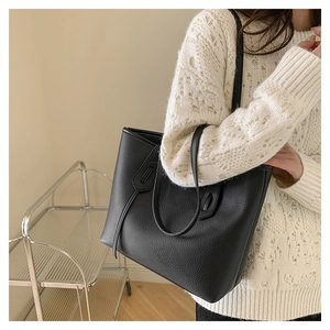 Close-up of black lychee grain tote bag showing premium PU leather texture and strap detail