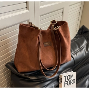 Detailed view of brown frosted tote bag with quilted texture and gold metal ring strap