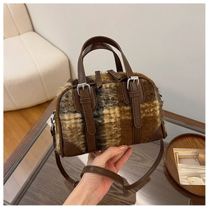 Detail shot of the plush plaid Boston bag with leather handles and metallic zippers