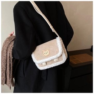 Détail du sac bandoulière d'hiver en daim beige avec écusson d'ours en peluche