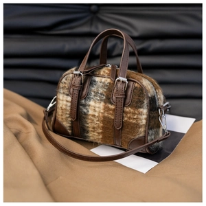 Detail of vintage plaid wool Boston bag showing brown leather handles and silver hardware