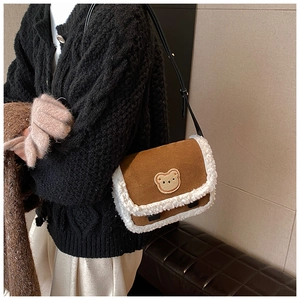 Détail d'un sac bandoulière d'hiver en daim marron avec bordure en laine de mouton