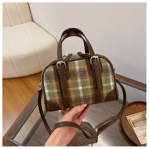Detail of plaid Boston bag with leather straps and adjustable shoulder strap