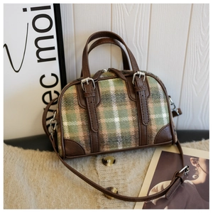 Detail of vintage plaid Boston bag with brown leather handles on soft knit sweater
