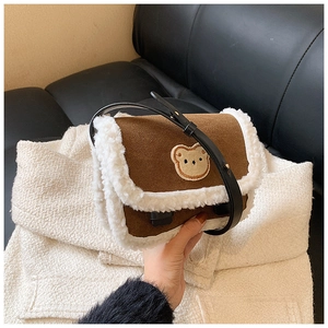 Détail du sac bandoulière en suédine marron avec peluche et broderie d'ourson mignon