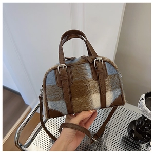 Detail of Boston bag showing checkered plush fabric and brown faux leather handle texture