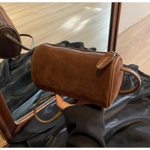 Detailed macro of dark brown frosted suede texture on a vintage cylinder Boston bag