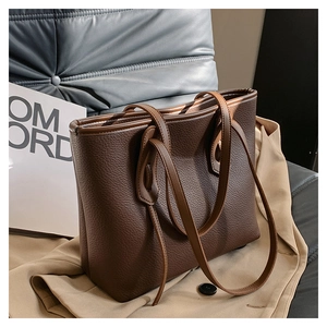 Detailed texture of a large dark brown tote bag on a trench coat and grey fabric seat