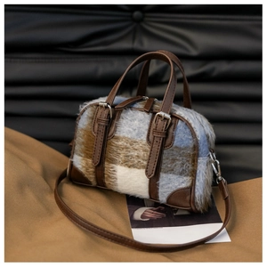 Close-up of a plaid faux fur Boston bag with leather handles and silver hardware detail