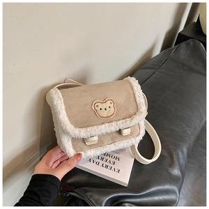 Détails de la bordure en polaire douce et ours brodé sur le sac en cuir beige