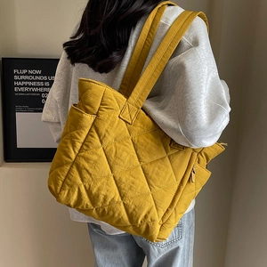 Quilted nylon tote bag in mustard yellow featuring spacious design and shoulder straps