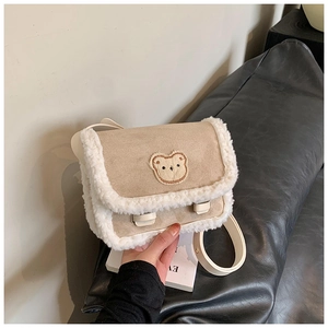 Détail du sac à bandoulière beige en suédine avec bordure polaire et broderie d'ours