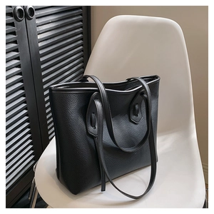 Detail of high-quality black lychee grain leather on a minimalist shoulder tote bag