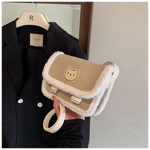 Détail de la bordure en polaire douce et écusson d'ours sur sac à bandoulière