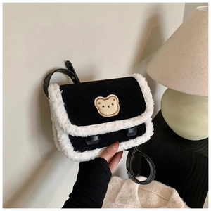 Détail de la bordure en faux mouton blanc et écusson ours sur le sac en velours noir