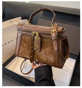 Detailansicht der braunen Handtasche in einer luxuriösen Geschenkbox mit Verpackung