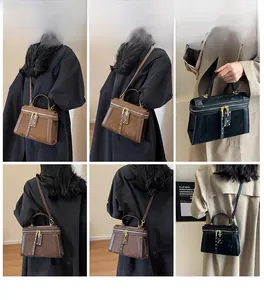 Detailansichten der Retro-Umhängetaschen aus mattem Leder in Braun und Schwarz am Modell
