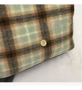 Macro detail of plaid wool fabric and premium golden magnetic buckle on casual backpack
