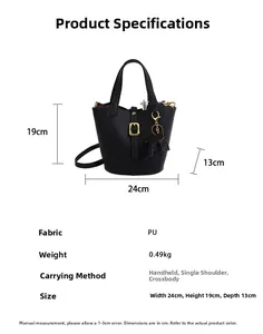 Detail of black lychee texture PU bucket bag with golden lock and cat pendant charm