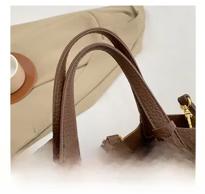 Close-up of litchi grain leather bucket bag with golden buckle and chain details