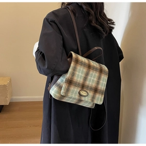 Detail of plush plaid backpack featuring brown check texture and slender straps