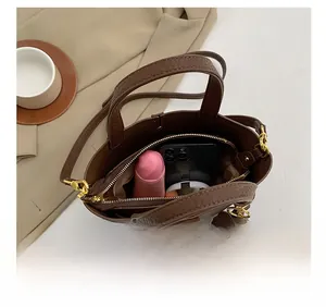 Top view of bucket bag interior capacity showing phone, lipstick, and makeup items