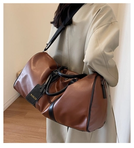 Side view of a large brown leather travel bag showing spacious capacity and premium texture