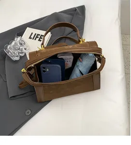 Detailansicht der geräumigen braunen Wildlederhandtasche mit Fokus auf das große Innenfach