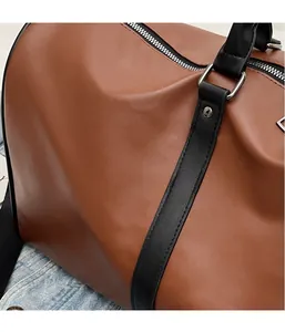 Detail of dark brown faux leather travel bag showing texture, stitching and metal zipper