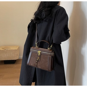 Detailansicht einer braunen Vintage-Umhängetasche mit mattem Finish und Goldbeschlägen