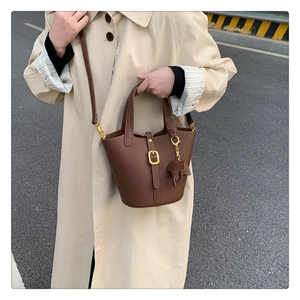 Detail einer braunen Bucket-Bag mit Leder-Elefanten-Anhänger und goldenen Schnallen
