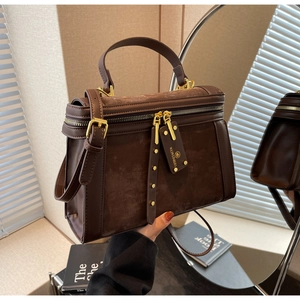 Nahaufnahme der braunen Wildleder-Retro-Handtasche mit goldfarbenen Reißverschlüssen