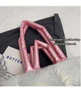 Detail of pink quilted handles and shiny nylon fabric on a white puffer tote bag