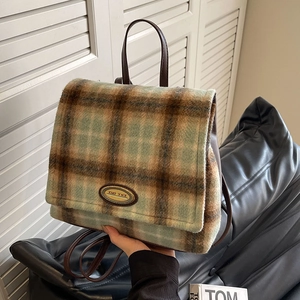 Retro green wool plaid backpack with leather straps and metal logo plate detail
