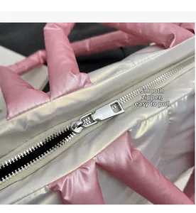 Detailansicht des glatten silbernen Metallreißverschlusses an einer gesteppten Tasche